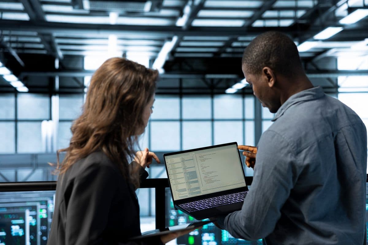 Profissionais de tecnologia revisam no notebook a integração da API de apuração da CBS