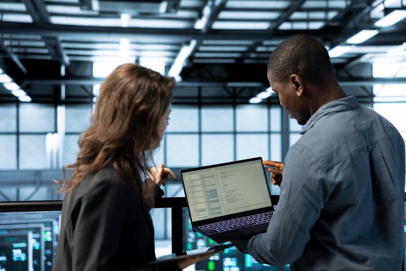 Profissionais de tecnologia revisam no notebook a integração da API de apuração da CBS