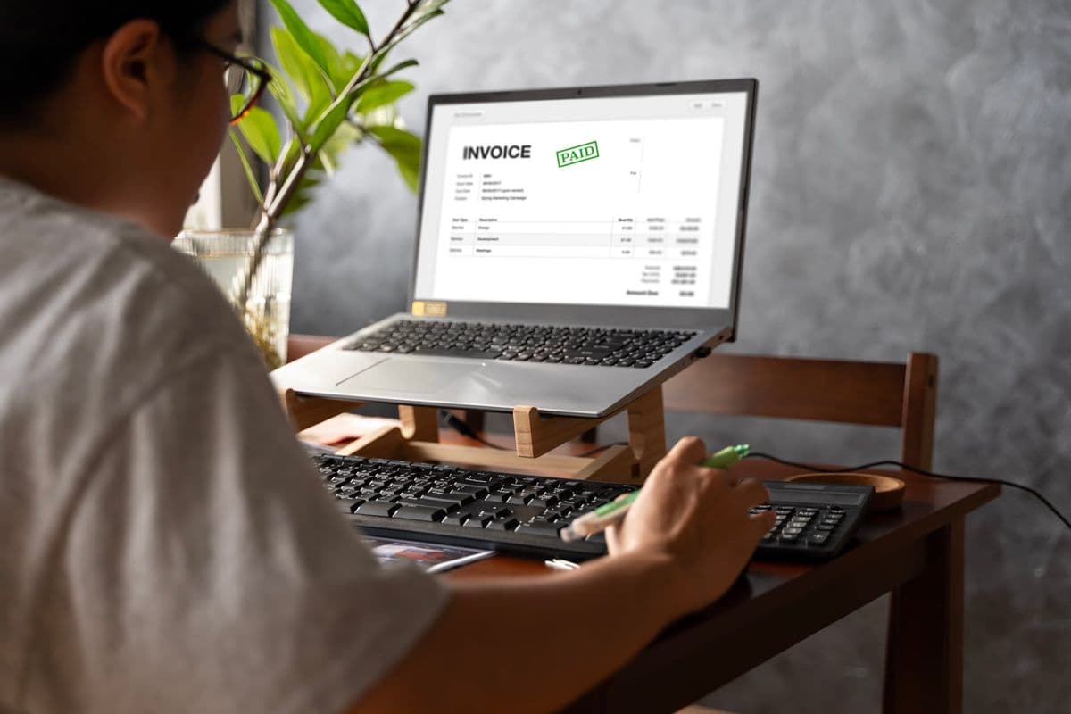 Profissional emite nota fiscal eletrônica em software de contabilidade no computador