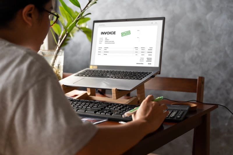 Profissional emite nota fiscal eletrônica em software de contabilidade no computador